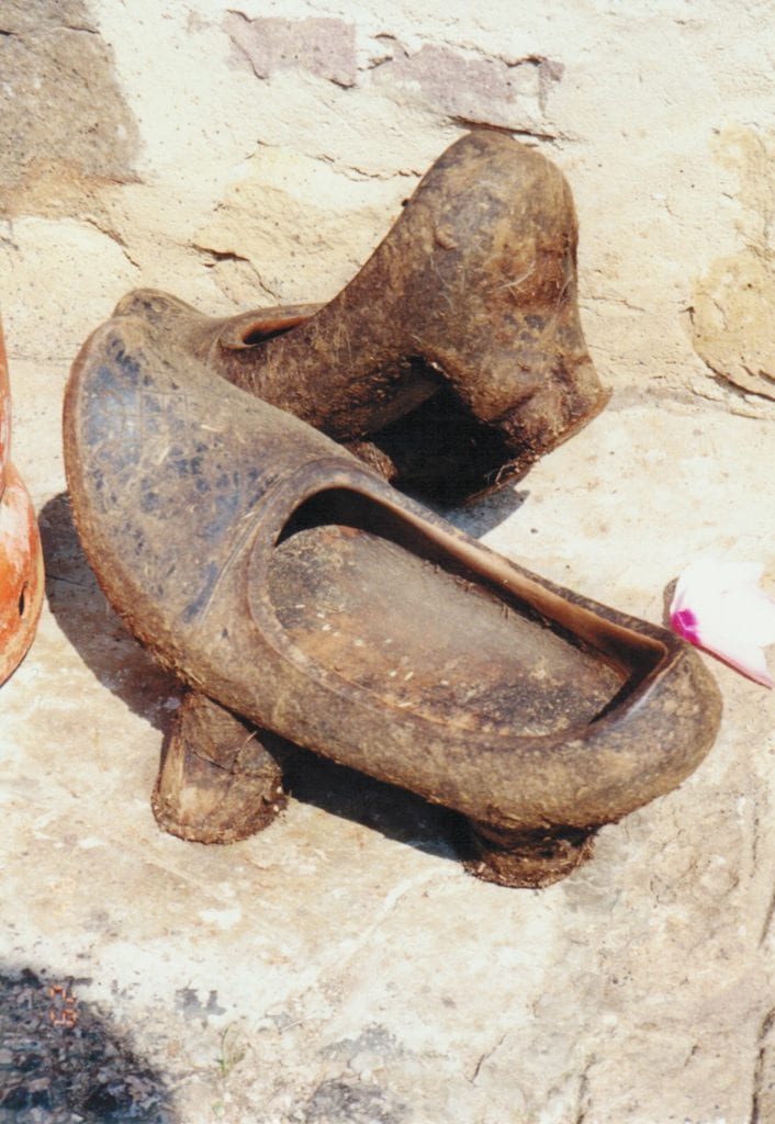 Ancient pottery vessel shaped like a shoe with a spout.