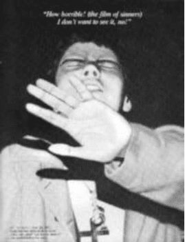Person blocking camera with hand, distressed expression.