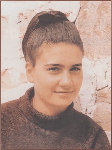 Young woman with high ponytail, smiling.