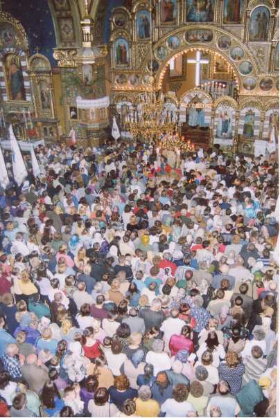 Crowded church interior with ornate decorations.