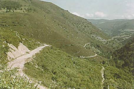 Mountainous landscape with winding dirt road.