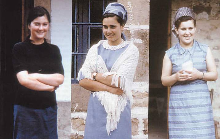 Three women standing in front of buildings.