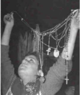 Person holding up multiple religious necklaces.