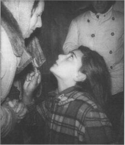Girl looking up at person in coat.