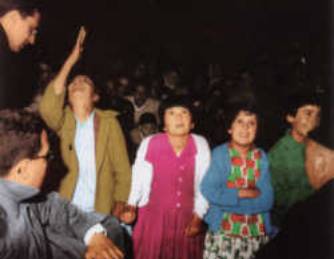People standing together in a dimly lit room.