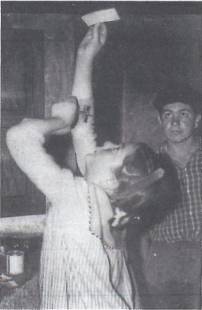 Person drinking from a glass, another observing.