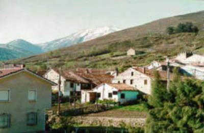 Mountain village with houses and distant peaks.