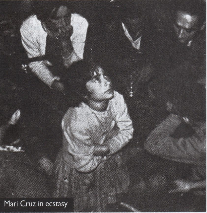 Child surrounded by people, looking upward.