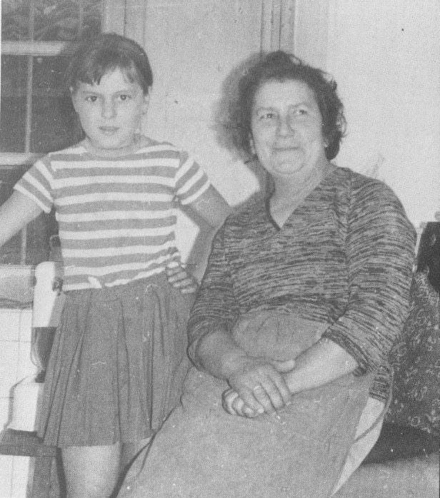 Girl and woman posing in a kitchen.