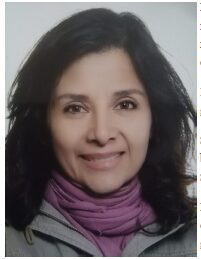 Smiling person with dark hair and scarf.