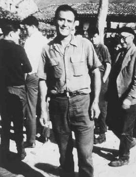 Smiling man standing among a group outdoors.