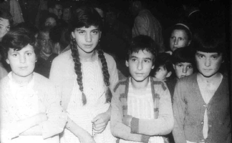 Group of children standing together, black-and-white.