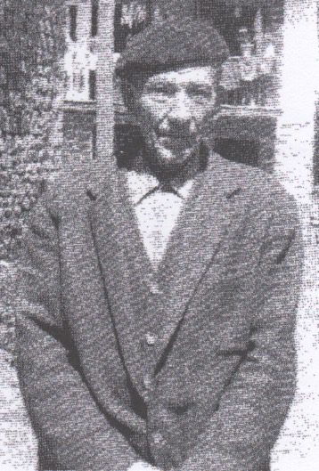 Man wearing a beret and coat outdoors.