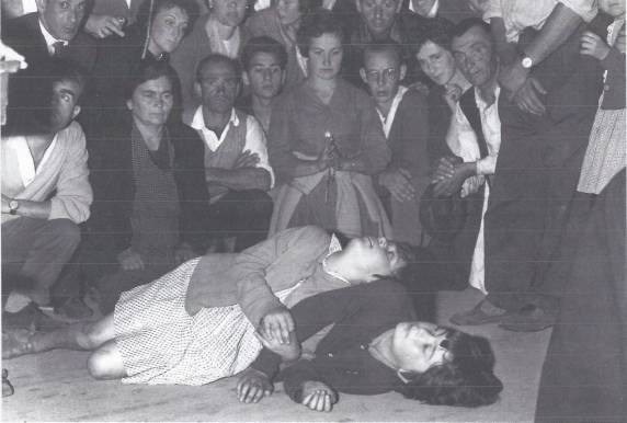People gathered around two women on ground.