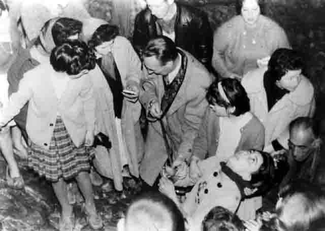 People gathered around a person on ground.