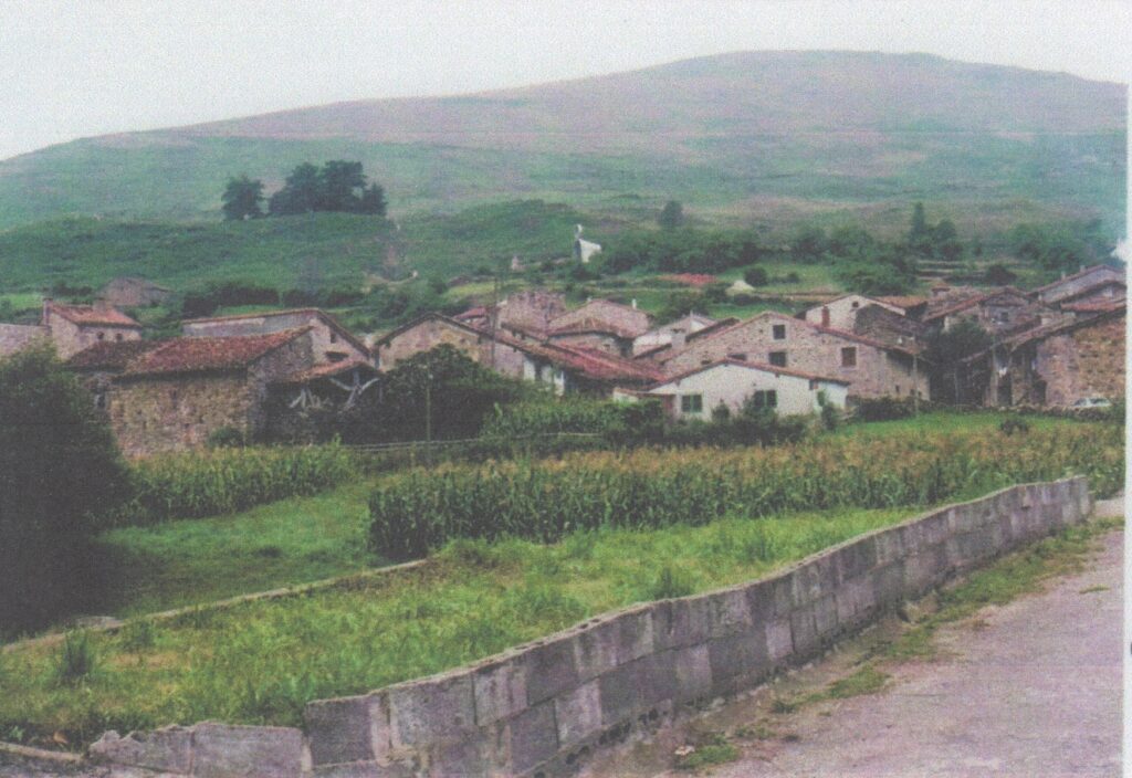 Rustic village with hills in background.