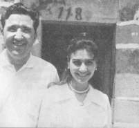 Smiling couple standing outside a building.